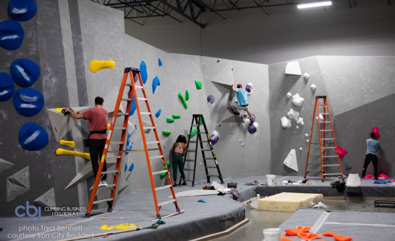 image of routesetters on climbing wall