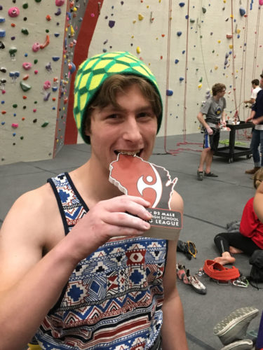 An athlete in Wisconsin's High School Climbing League holds an award.