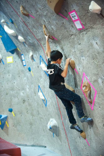 Young climber doing dynamic movement