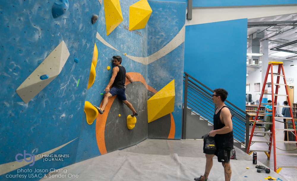 image of climbers in gym on yellow holds